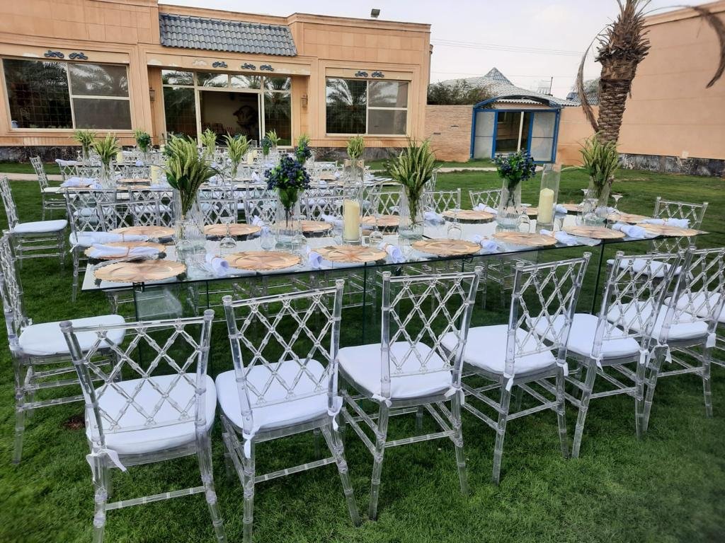 تنسيق طاولة زجاجية طويلة مع شموع وورود