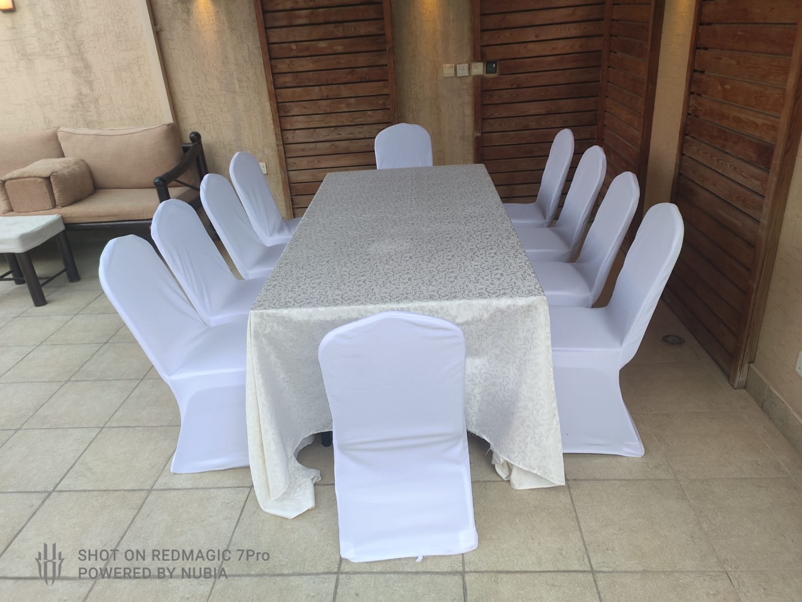 تنسيق طاولة بغطاء فضي وكراسي بيضاء
