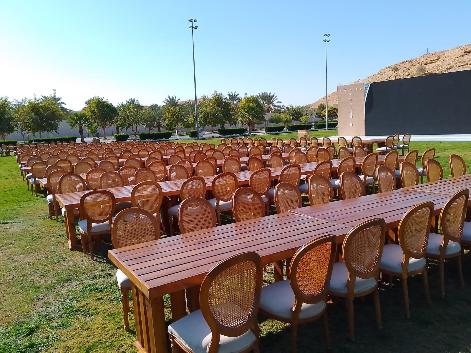 فعالية خارجية كبيرة بطاولات خشبية وكراسي كين