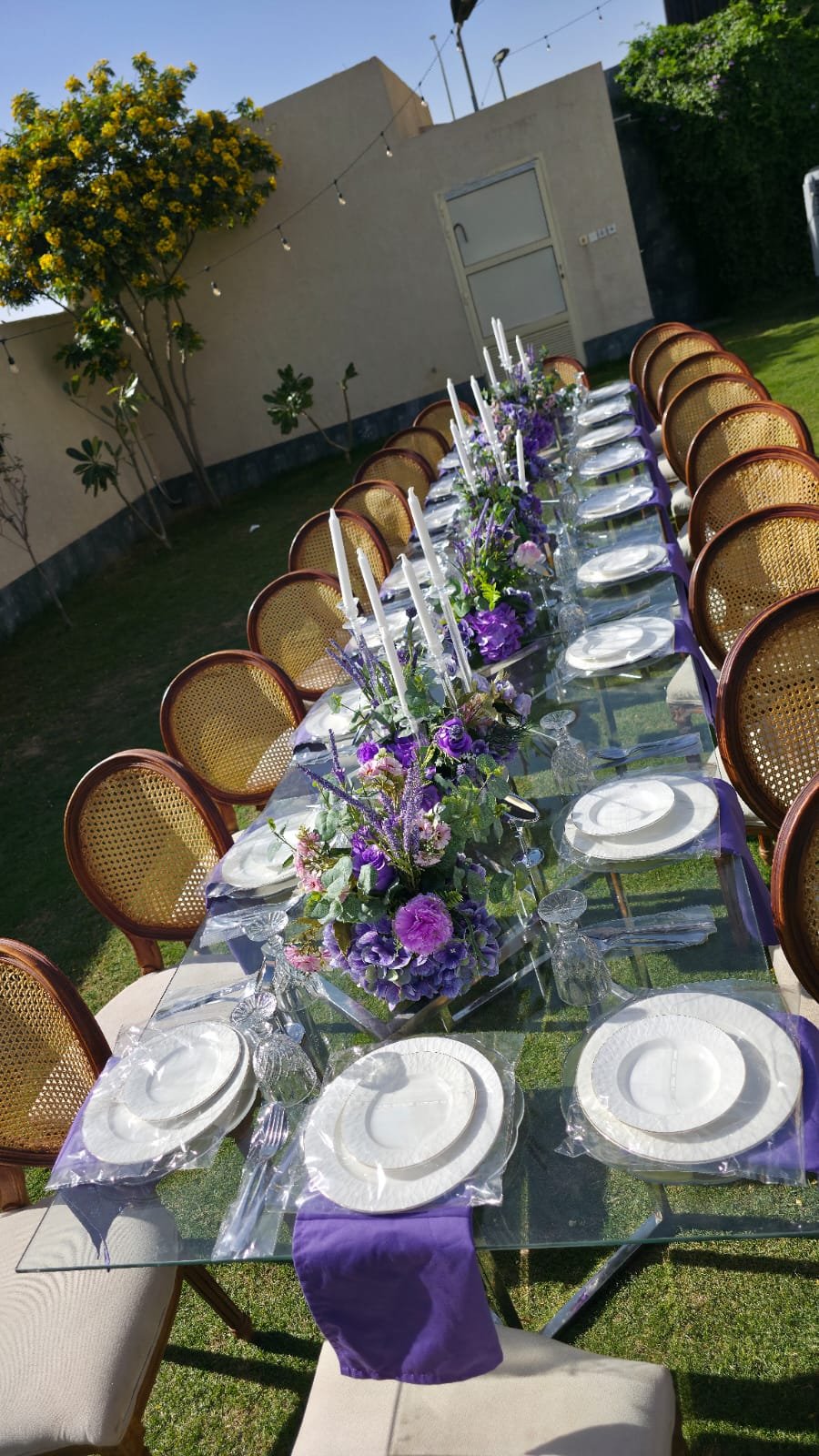 طاولة زجاجية خارجية طويلة بمناديل بنفسجية